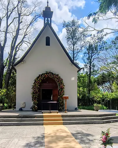 Alfombra para ceremonia frente a una capilla con arco floral
