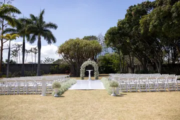 Ceremonia en jardín con arco blanco y pasillo de gipsofila