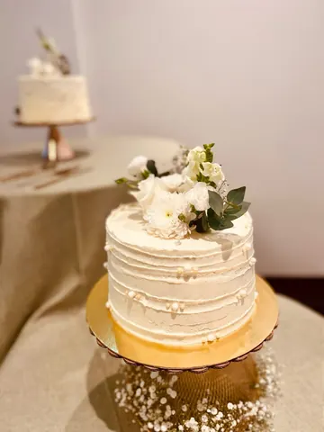 Pastel con flores blancas sobre base dorada