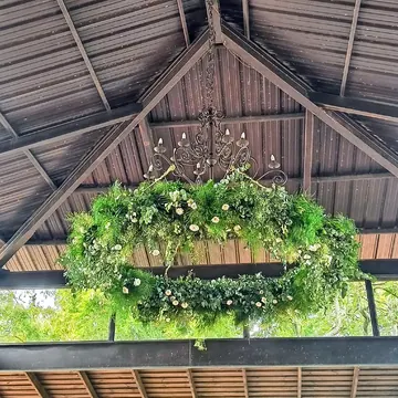 Corona floral suspendida con follaje y gipsofila