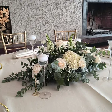 Mesa principal en blanco con eucalipto y velas