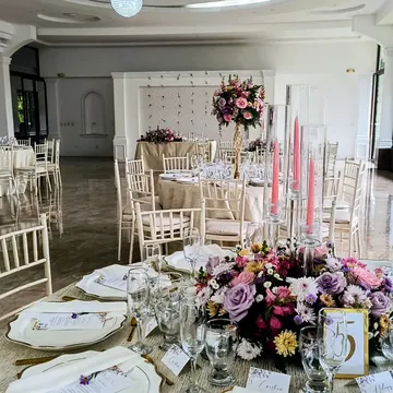 Salón con velas rosadas y centros altos