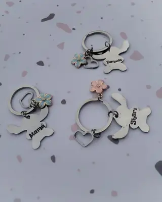 Llaveros grabados con nombres, con sus dijes de flor y corazón