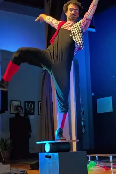 Kachevaches en equilibrio sobre la rola bola, con los brazos abiertos, bajo luz azul