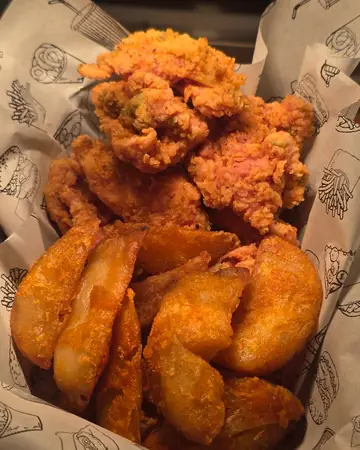Pollo frito y papas gajo en la bolsa de papel de Pollo Elí